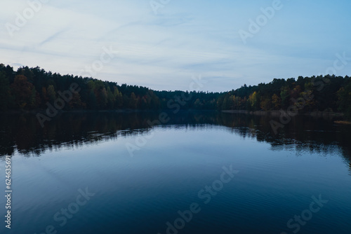 Stunningly beautiful lake in the golden autumn season. Magical multi-color reflection with light ripples on the surface of the water fall evening. Autumn scenery Colorful vibrant autumn forest with
