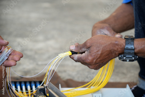 Technician is using duct tape. with fiber optic cable before installing into the FTTH terminal box.