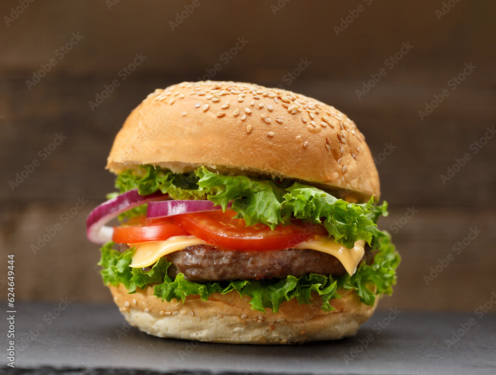Juicy appetizing burger with beef on a dark background, homemade hamburger, fast food. Juicy appetizing burger with beef on a dark background, homemade hamburger, fast food.