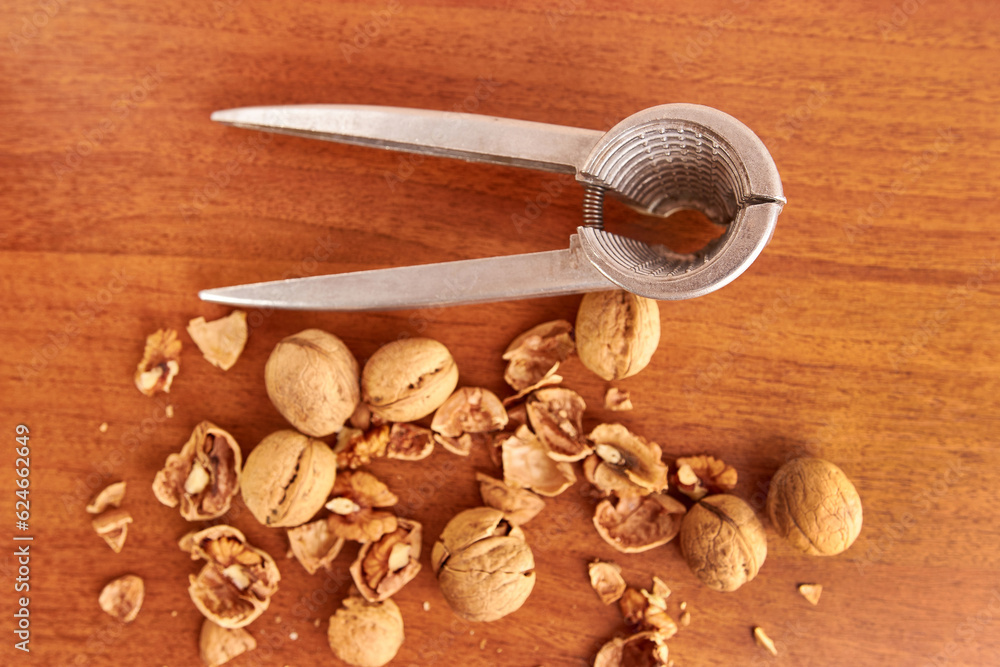 Walnuts are crushed with a nutcracker. Kitchen appliances for work in the kitchen.