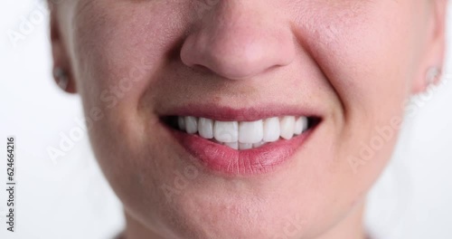 Woman smiles widely with white teeth on white background. Female person shows perfectly maintained oral cavity. Concept of treatment at dentist and regular checkups