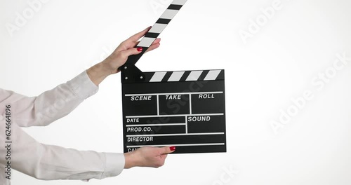 Female hands clip using black clapboard to give signal to start shooting film. Woman assistant against isolated white background during set photo