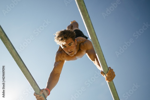 Fotografie Strong young sportsman doing calisthenics