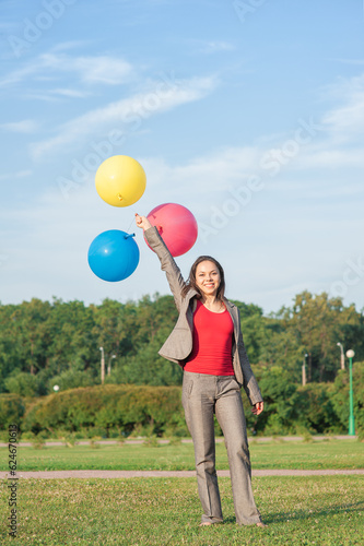 Young beautiful happy barefoot business woman with long hair with air balloons outdoor
