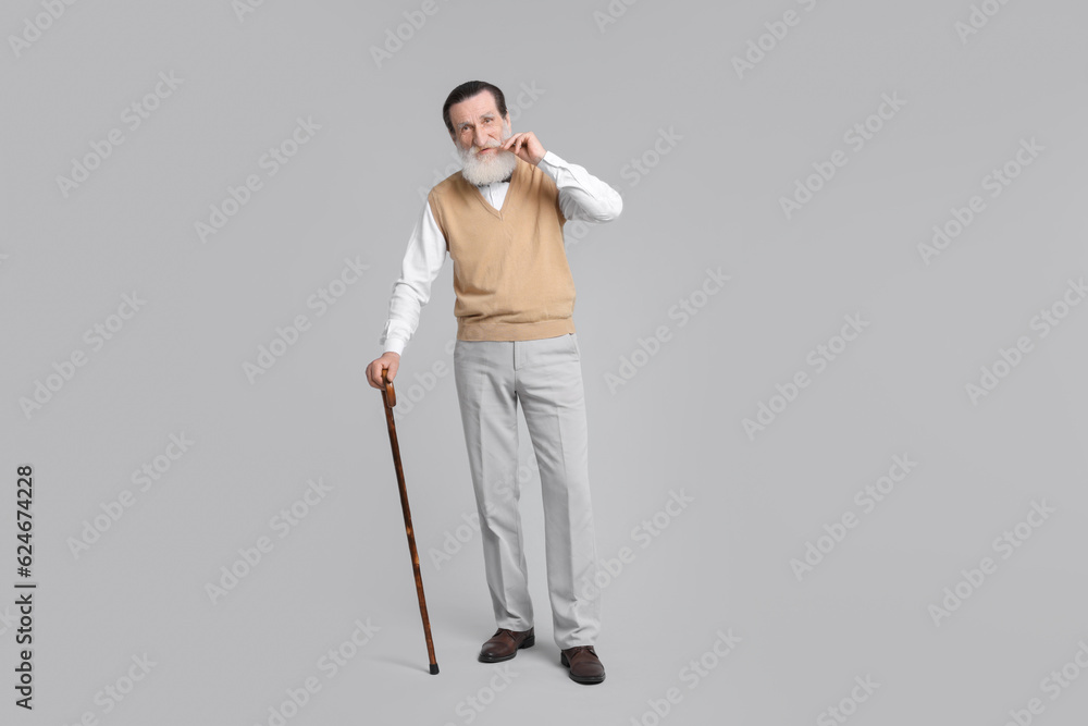 Senior man with walking cane on light gray background Senior man with walking cane on light gray background