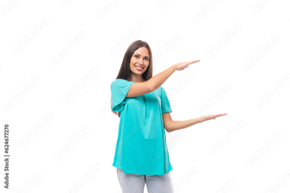 portrait of a young caucasian brunette woman in a blue t-shirt showing the dimensions of an object on a white background with copy space portrait of a young caucasian brunette woman in a blue t-shirt showing the dimensions of an object on a white background with copy space