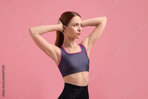 Young woman in sportswear on pink background