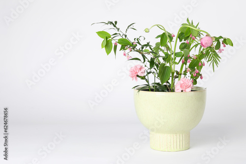 Beautiful ikebana for stylish house decor. Floral composition with fresh flowers and branches on white background, space for text