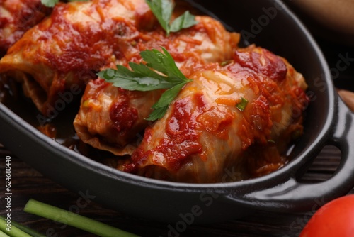 Delicious stuffed cabbage rolls cooked with homemade tomato sauce on table, closeup