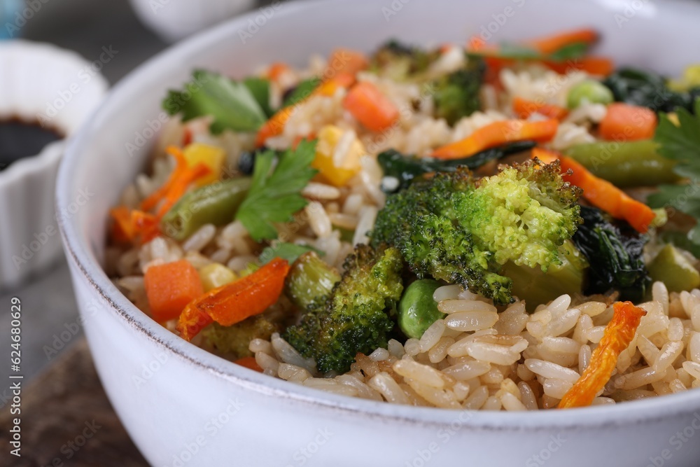 Tasty fried rice with vegetables in bowl, closeup Tasty fried rice with vegetables in bowl, closeup