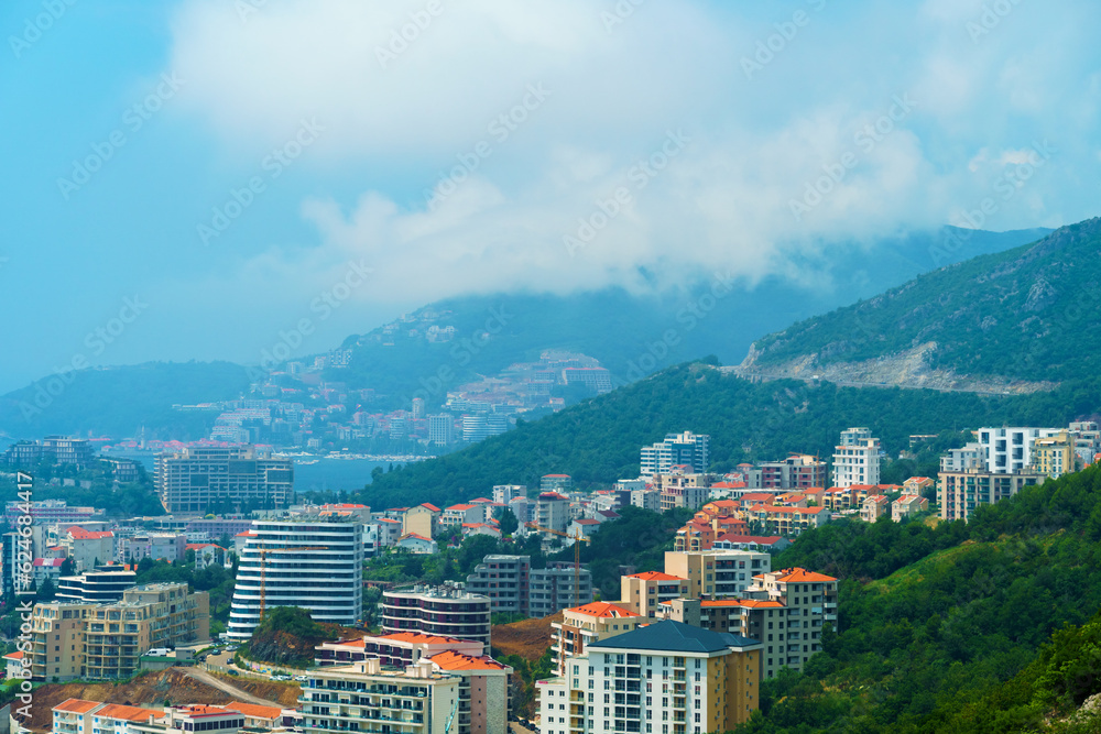 aerial view of the city on the seashore and mountains, panorama of the resorts of Becici and Budva in Montenegro, Adriatic sea, beaches, islands, tourism and travel, summer traveling