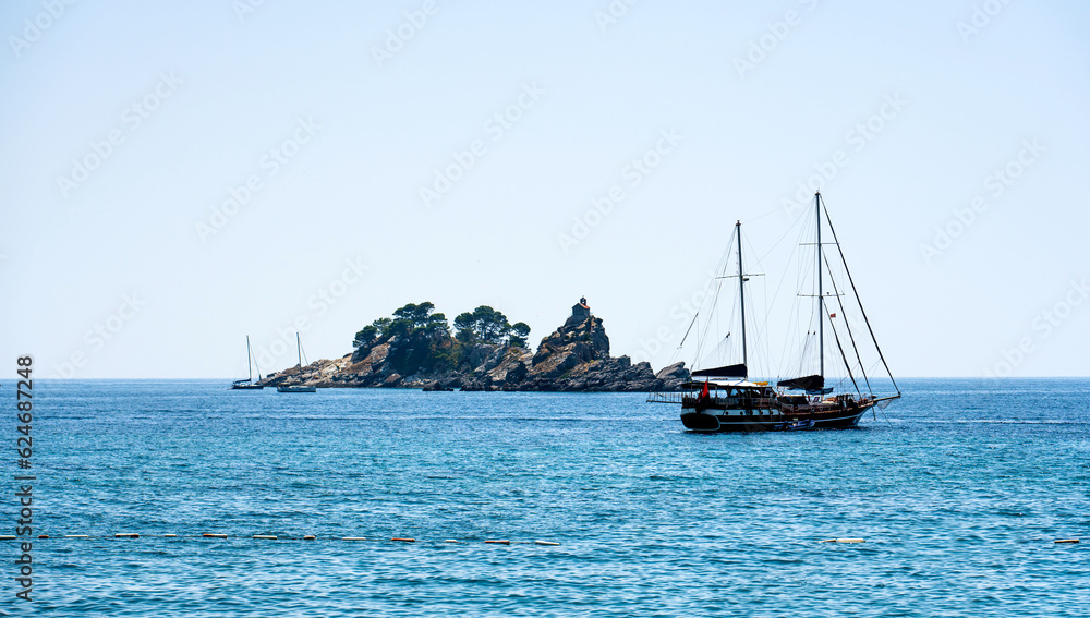 Touristic boat in Adriatic sea in Montenegro close to island in sunny day. Beautiful Mediterranean nature Touristic boat in Adriatic sea in Montenegro close to island in sunny day. Beautiful Mediterranean nature