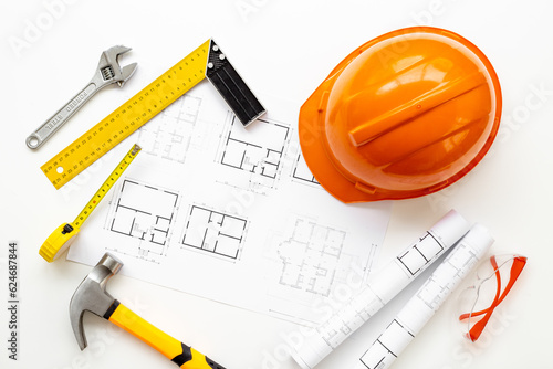 Top view of construction helmet on drawing blueprints for house designing and architect plan