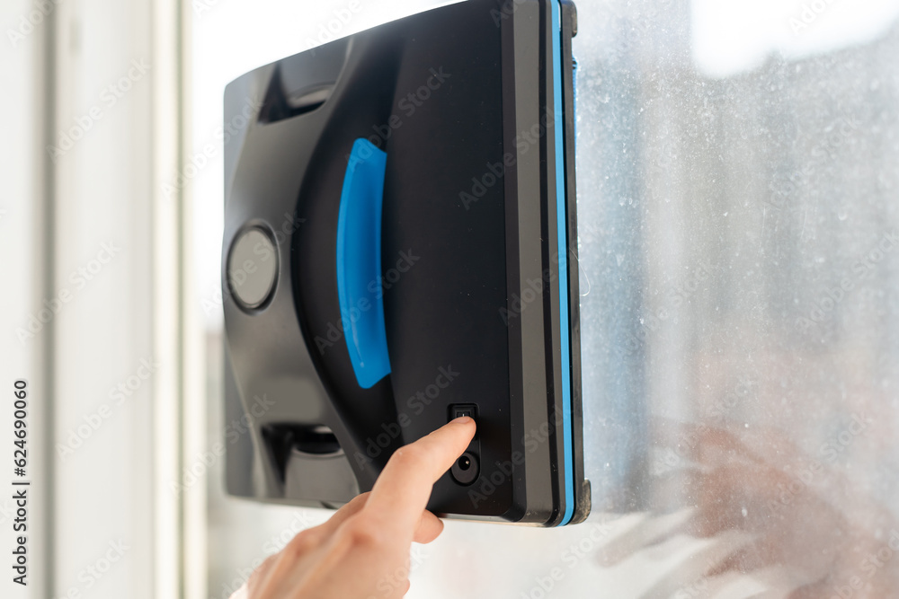 Modern window washer robot performs work on a dirty window. Cleaning the house with smart devices. Automatic window cleaning robot, housekeeper Modern window washer robot performs work on a dirty window. Cleaning the house with smart devices. Automatic window cleaning robot, housekeeper