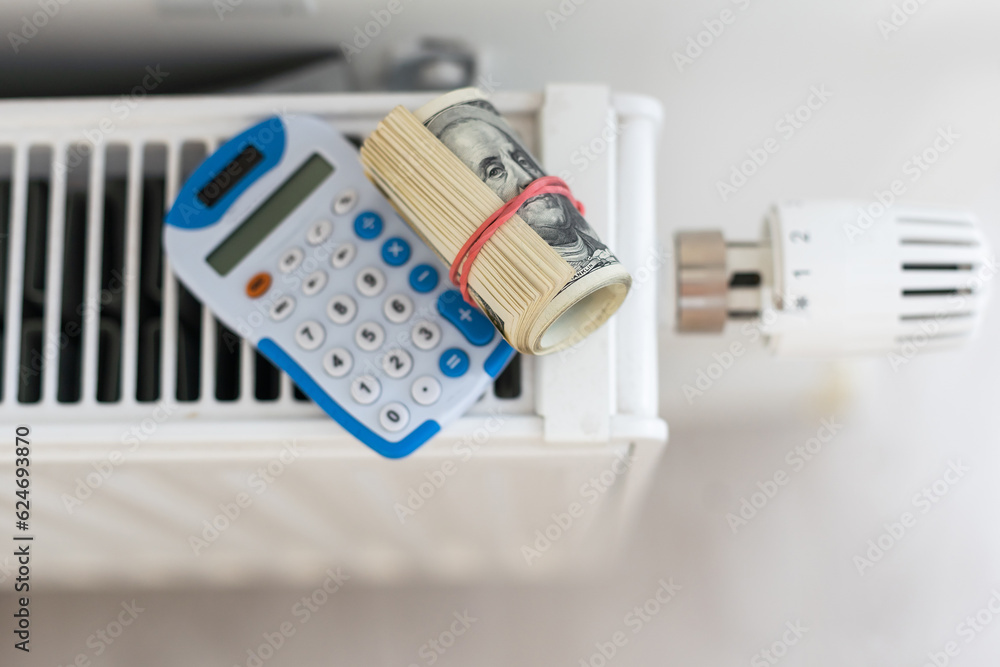 heating thermostat with money, one dollar, expensive heating costs concept
