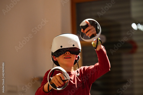 Teenage boy with wirtual headset and controllers playing virtual video games