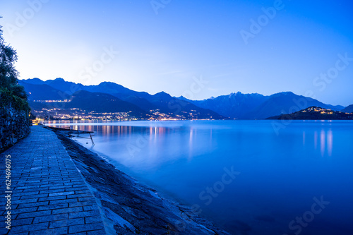 Il paese di Pianello del lario, sul lago di Como, e la passeggiata lungo il lago, all'imbrunire. Alpi, montagne e paesi del lago in lontananza. photo