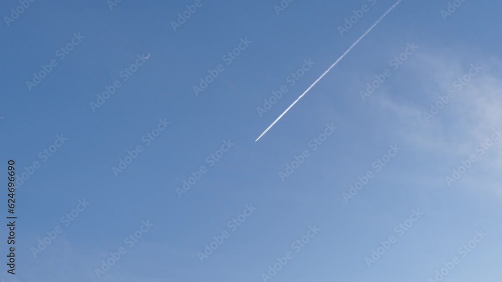 Blue sky with airplane in flight with white contrail and helicopter flying below - real time. Topics: travel, transport, space, weather Blue sky with airplane in flight with white contrail and helicopter flying below - real time. Topics: travel, transport, space, weather