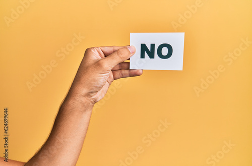 Hand of caucasian man holding paper with no word over isolated yellow background photo