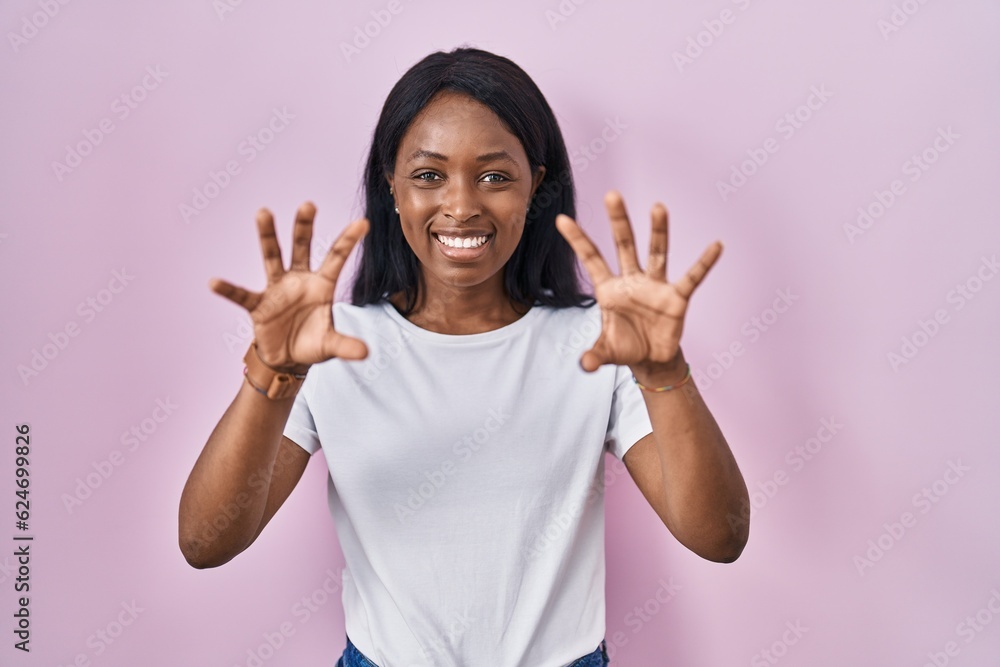 African young woman wearing casual white t shirt smiling funny doing claw gesture as cat, aggressive and sexy expression African young woman wearing casual white t shirt smiling funny doing claw gesture as cat, aggressive and sexy expression