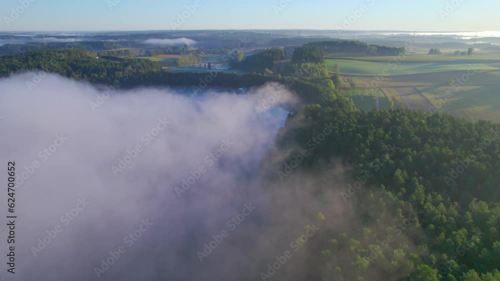 Amazing Nature Landscape Wonderful Morning Sunrise. Sun Rays Break Through Foliage and Fog of Trees. Early Morning Fog Rising up Above Shiny Hills. Aerial View of Farmland Foggy Morning in Poland. Amazing Nature Landscape Wonderful Morning Sunrise. Sun Rays Break Through Foliage and Fog of Trees. Early Morning Fog Rising up Above Shiny Hills. Aerial View of Farmland Foggy Morning in Poland.