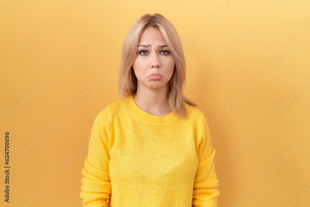 Φωτογραφία Young caucasian woman wearing yellow sweater depressed and worry for distress, crying angry and afraid