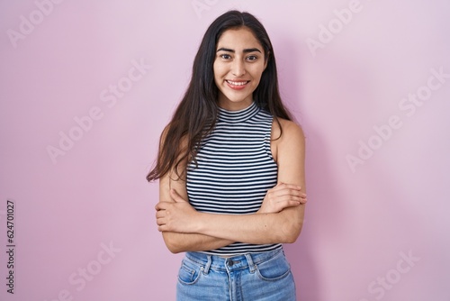 Young teenager girl wearing casual striped t shirt happy face smiling with crossed arms looking at the camera. positive person.