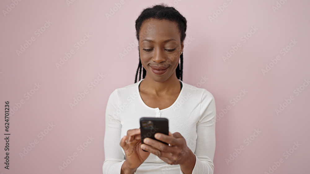 African american woman smiling confident using smartphone over isolated pink background African american woman smiling confident using smartphone over isolated pink background