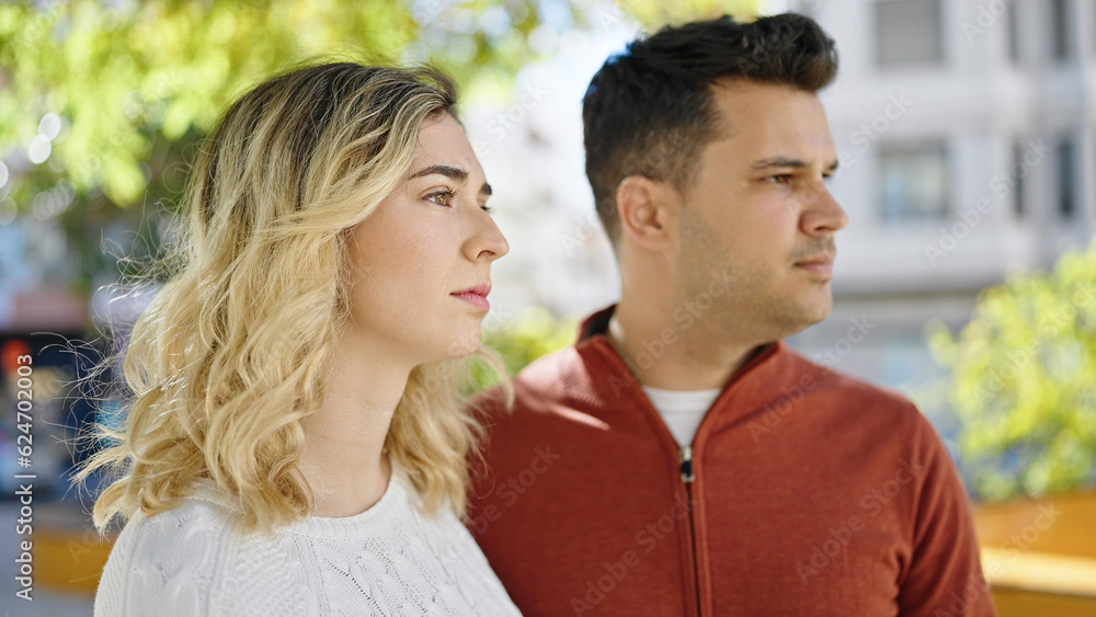 Man and woman couple standing together with relaxed expression at park Man and woman couple standing together with relaxed expression at park