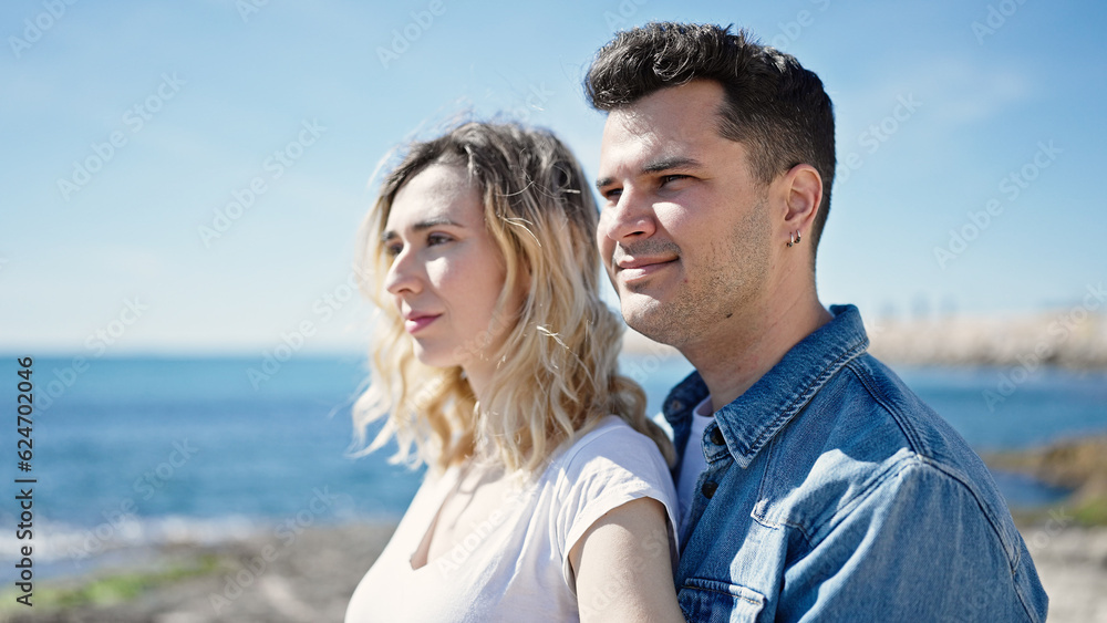 Man and woman couple smiling confident standing together at seaside Man and woman couple smiling confident standing together at seaside