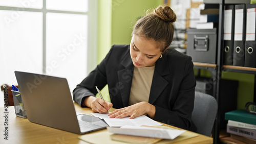 Young beautiful hispanic woman business worker writing letter at office