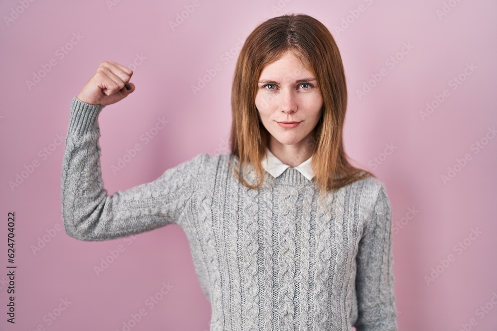 Beautiful woman standing over pink background strong person showing arm muscle, confident and proud of power Beautiful woman standing over pink background strong person showing arm muscle, confident and proud of power