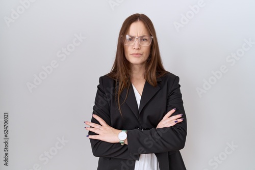 Beautiful brunette woman wearing business jacket and glasses skeptic and nervous, disapproving expression on face with crossed arms. negative person.