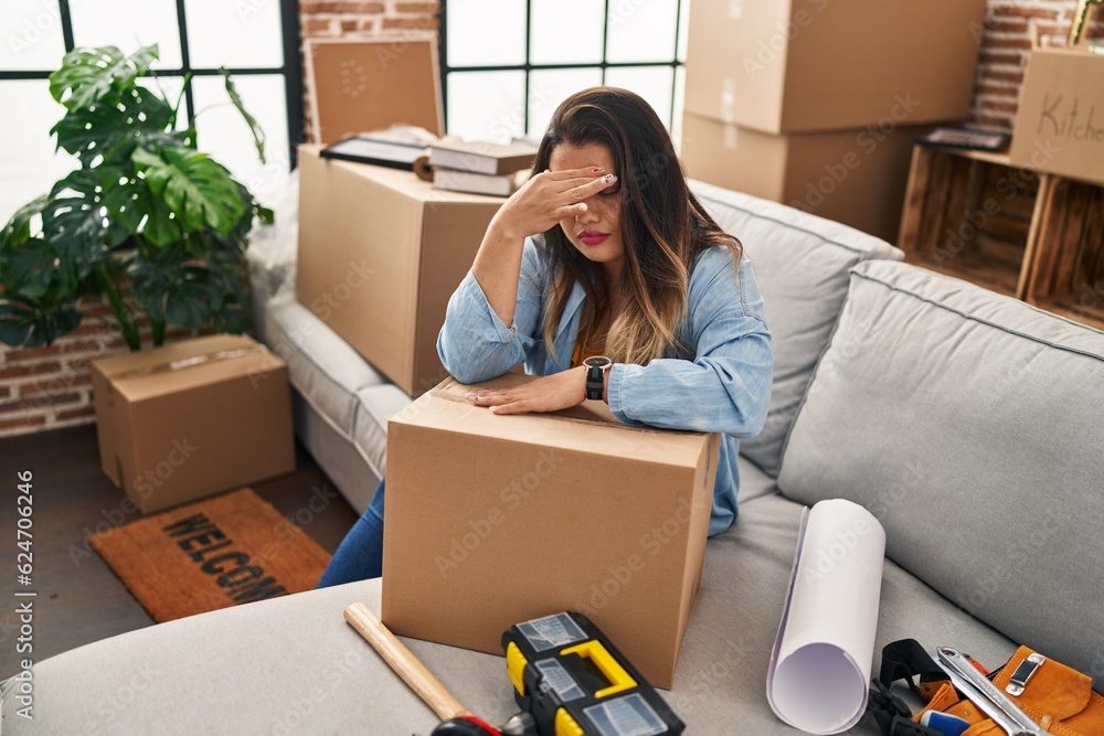 Young beautiful plus size woman stressed sitting on sofa at new home Young beautiful plus size woman stressed sitting on sofa at new home