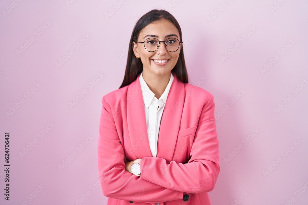 Young hispanic woman wearing business clothes and glasses happy face smiling with crossed arms looking at the camera. positive person. Young hispanic woman wearing business clothes and glasses happy face smiling with crossed arms looking at the camera. positive person.