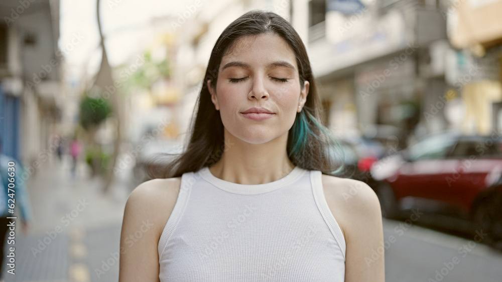 Young beautiful hispanic woman breathing with closed eyes at street
