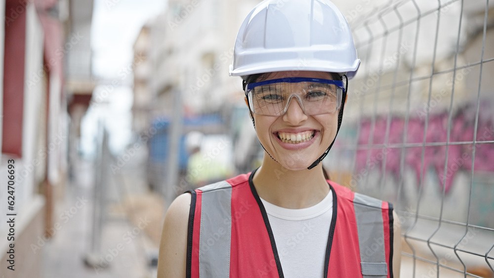 Young beautiful hispanic woman builder smiling confident standing at street Young beautiful hispanic woman builder smiling confident standing at street
