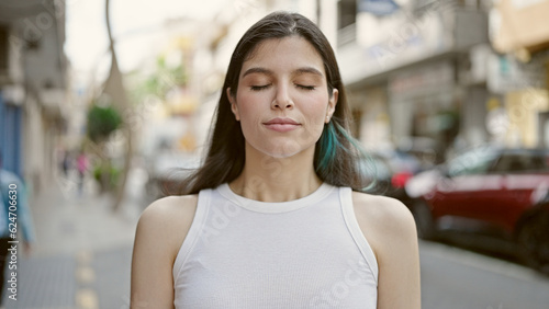 Young beautiful hispanic woman breathing with closed eyes at street © Krakenimages.com