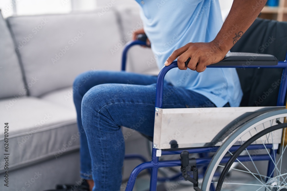 Young latin man sitting on wheelchair at home Young latin man sitting on wheelchair at home