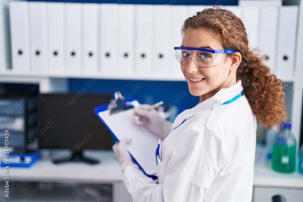 Young beautiful hispanic woman scientist writing report working at laboratory Young beautiful hispanic woman scientist writing report working at laboratory