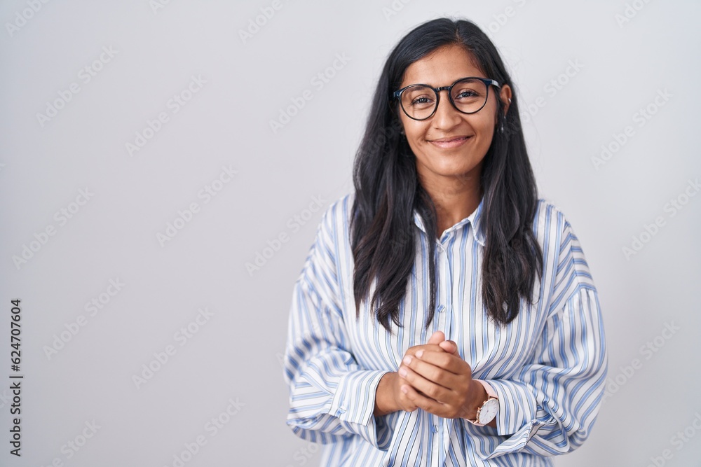 Young hispanic woman wearing glasses with hands together and crossed fingers smiling relaxed and cheerful. success and optimistic Young hispanic woman wearing glasses with hands together and crossed fingers smiling relaxed and cheerful. success and optimistic