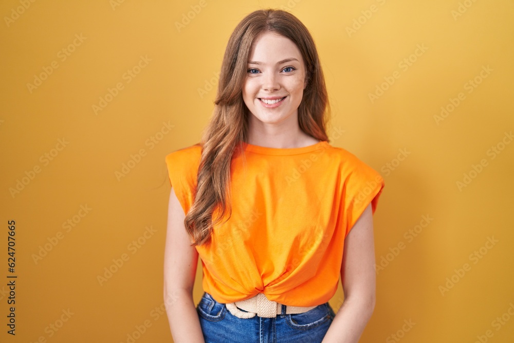 Caucasian woman standing over yellow background with a happy and cool smile on face. lucky person. Caucasian woman standing over yellow background with a happy and cool smile on face. lucky person.