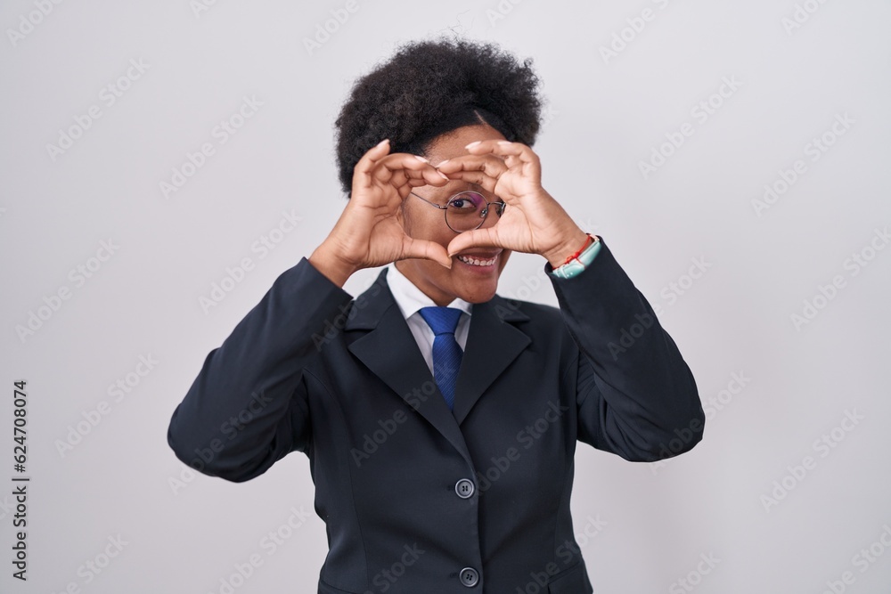Beautiful african woman with curly hair wearing business jacket and glasses doing heart shape with hand and fingers smiling looking through sign Beautiful african woman with curly hair wearing business jacket and glasses doing heart shape with hand and fingers smiling looking through sign