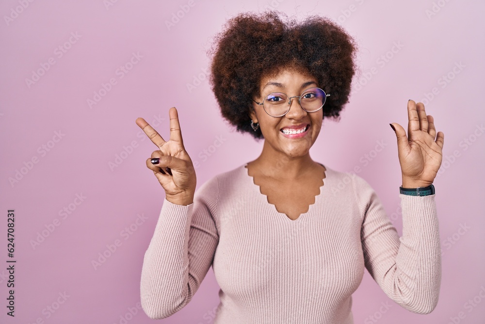 Young african american woman standing over pink background showing and pointing up with fingers number seven while smiling confident and happy. Young african american woman standing over pink background showing and pointing up with fingers number seven while smiling confident and happy.