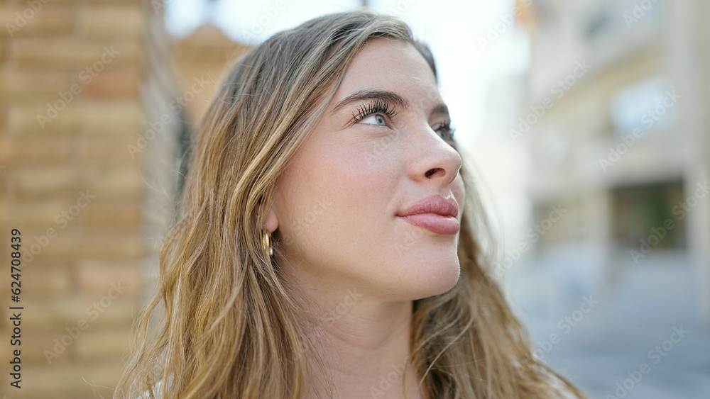 Young blonde woman smiling confident looking to the sky at street Young blonde woman smiling confident looking to the sky at street