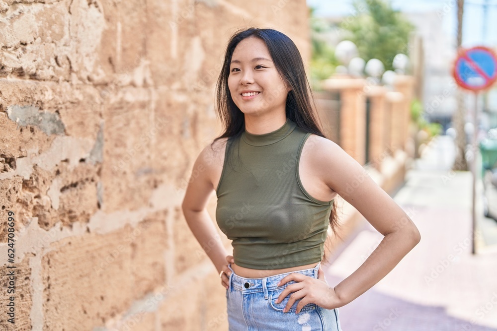 Young chinese woman smiling confident looking to the side at street Young chinese woman smiling confident looking to the side at street