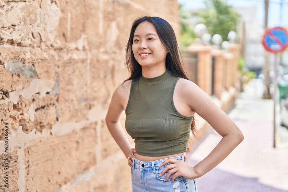 Young chinese woman smiling confident looking to the side at street