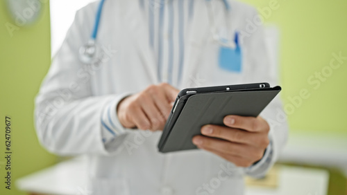 Young hispanic man doctor using touchpad at clinic © Krakenimages.com