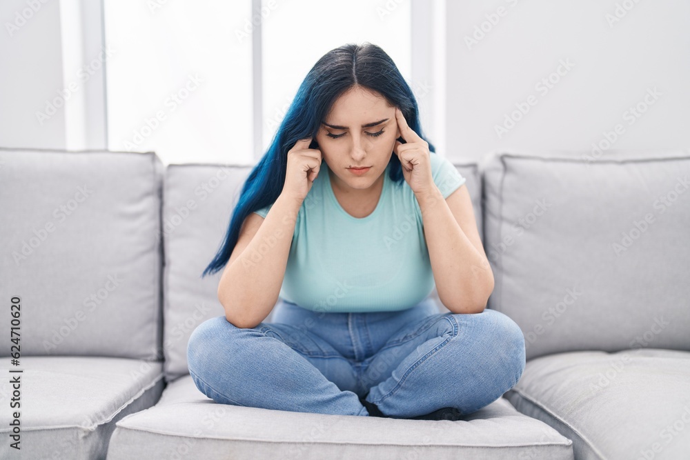 Young caucasian woman stressed sitting on sofa at home Young caucasian woman stressed sitting on sofa at home