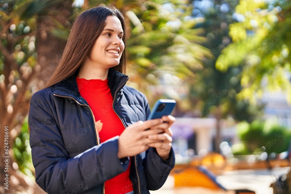 Young beautiful hispanic woman smiling confident using smartphone at park
